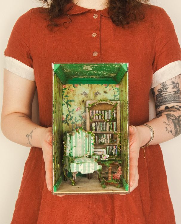 Bronte Huskinson From Bee With Love holding her miniature library Book nook in red dress